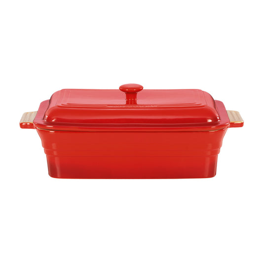 Red ceramic baking dish with wooden handles on a white background