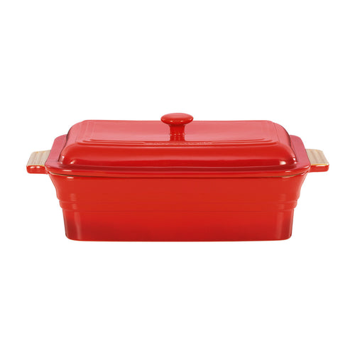 Red ceramic baking dish with wooden handles on a white background