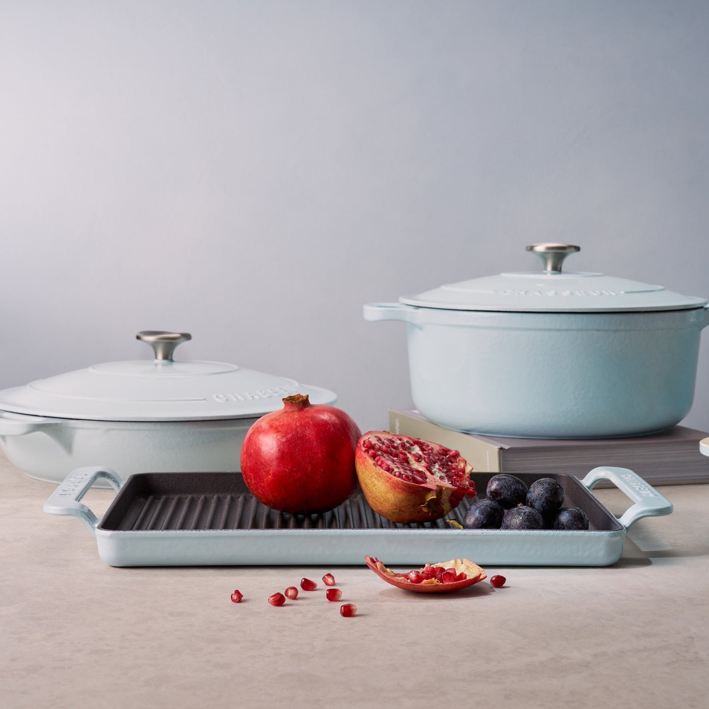 Set of cookware with fruits on a neutral background